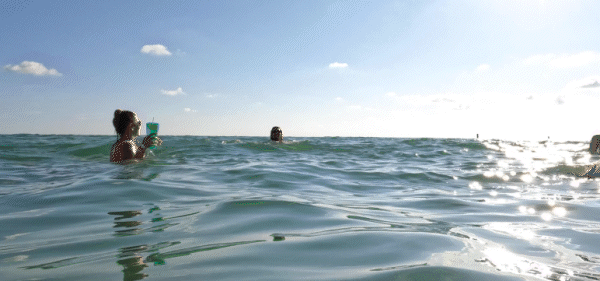 A gif of three women swimming in the ocean